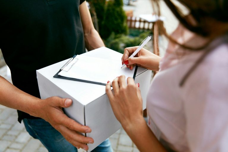 A person receiving a package and signing for it with a pen. A person receiving a package and signing for it with a pen.